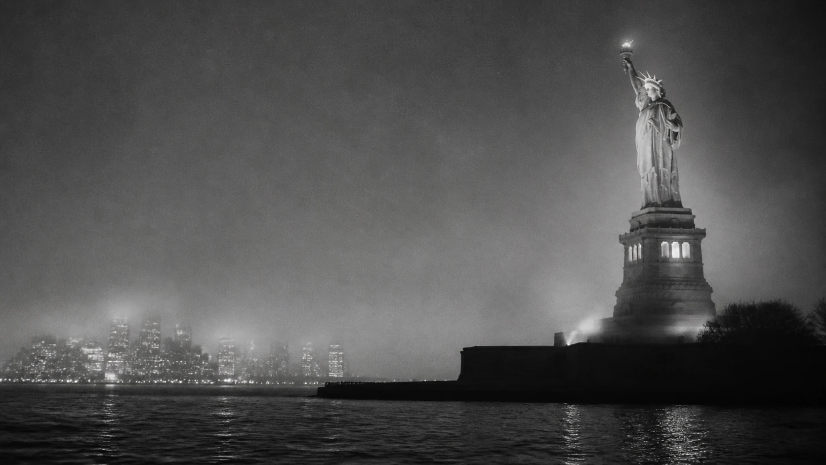 Grainy nighttime view of the Statue of Liberty and New York Harbor